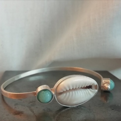 Pulseira em metal prateado com concha branca e pedras verdes