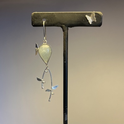 Brinco pendente de metal prateado com pedra branca em forma de lágrima