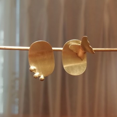 Brincos dourados metálicos assimétricos com detalhes arredondados e borboleta