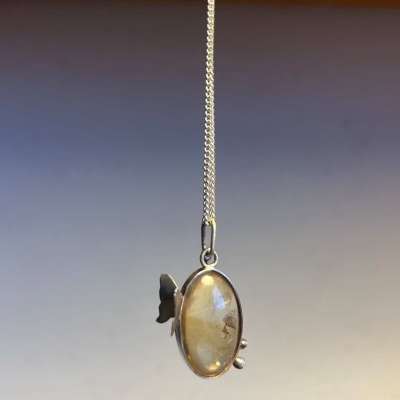 Colar com pendente oval de pedra amarela e metal prateado