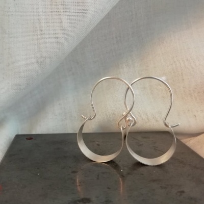 Brincos de metal prateado em forma circular com gancho fino