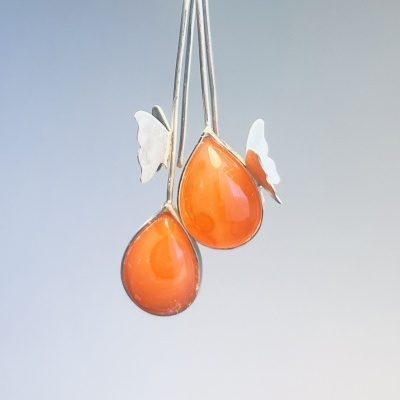Brincos com pedras laranja em forma de gota e borboletas prateadas