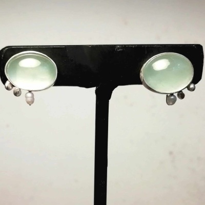 Brincos verdes claros ovais com pendentes pérola em suporte preto