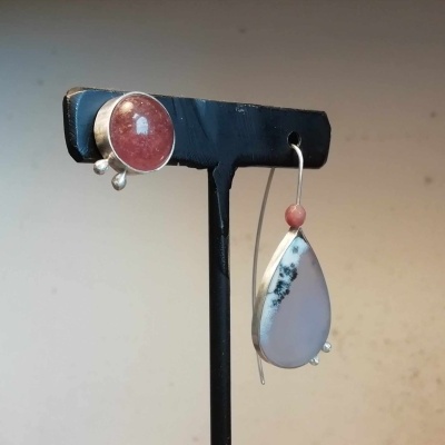 Par de brincos pendentes com pedras vermelha e branca em suporte preto