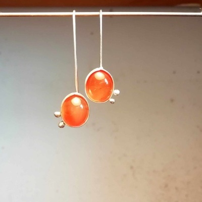 Brincos com pedras laranja translúcidas em armação metálica prateada