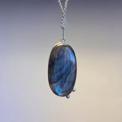 Colar com pendente oval em pedra labradorite azul e cinzento suspenso por corrente prateada
