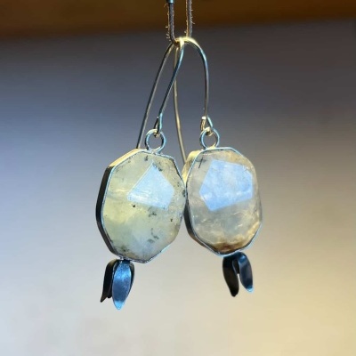 Brincos com pedras facetadas e detalhes metálicos suspensos por fio