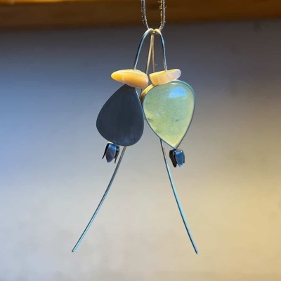 Brincos pendentes com pedras em forma de gota preta e verde translúcida