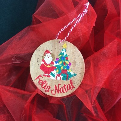 Enfeite de Natal redondo em cortiça com Pai Natal, árvore de Natal e texto Feliz Natal