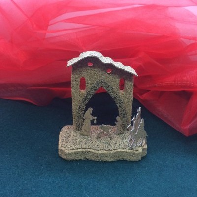 Miniatura de presépio em madeira ou cortiça com figuras religiosas e fundo de tecido vermelho