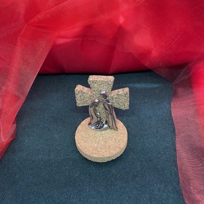 Objeto decorativo com base e cruz em cortiça e figuras metálicas de casal abraçado