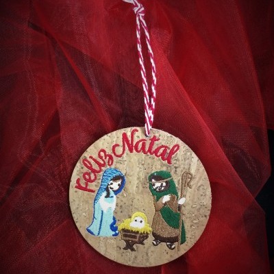 Ornamento natalício redondo em cortiça com personagens do presépio e texto Feliz Natal