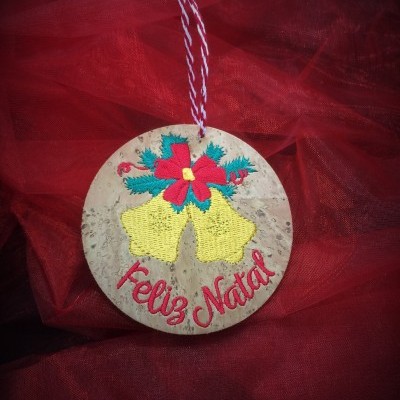 Ornamento de Natal redondo de cortiça com sinos amarelos e frase Feliz Natal