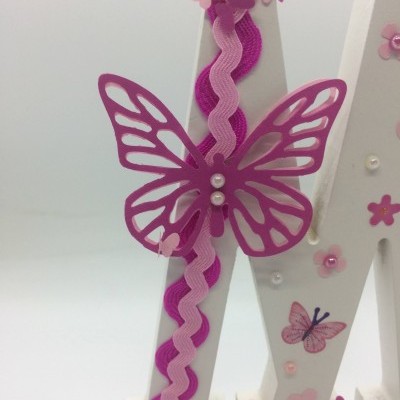 Letra decorativa branca com borboletas e flores rosa e lilás