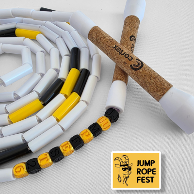 Jump rope with cork handles and colorful segmented cord, lettered beads, and yellow sticker on white background