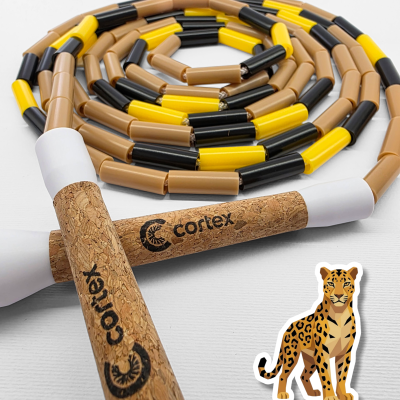 Jump rope with cork handles and brown, yellow, and black beaded rope on white background with leopard sticker