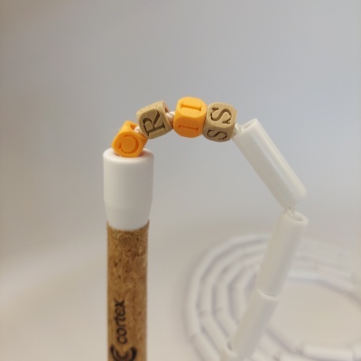 Fishing rod handle with beads spelling CRISIS and white segmented plastic structure