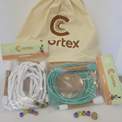Two different skipping ropes with cork handles, beige drawstring bag labeled Cortex, and colored beads spelling CORTEX