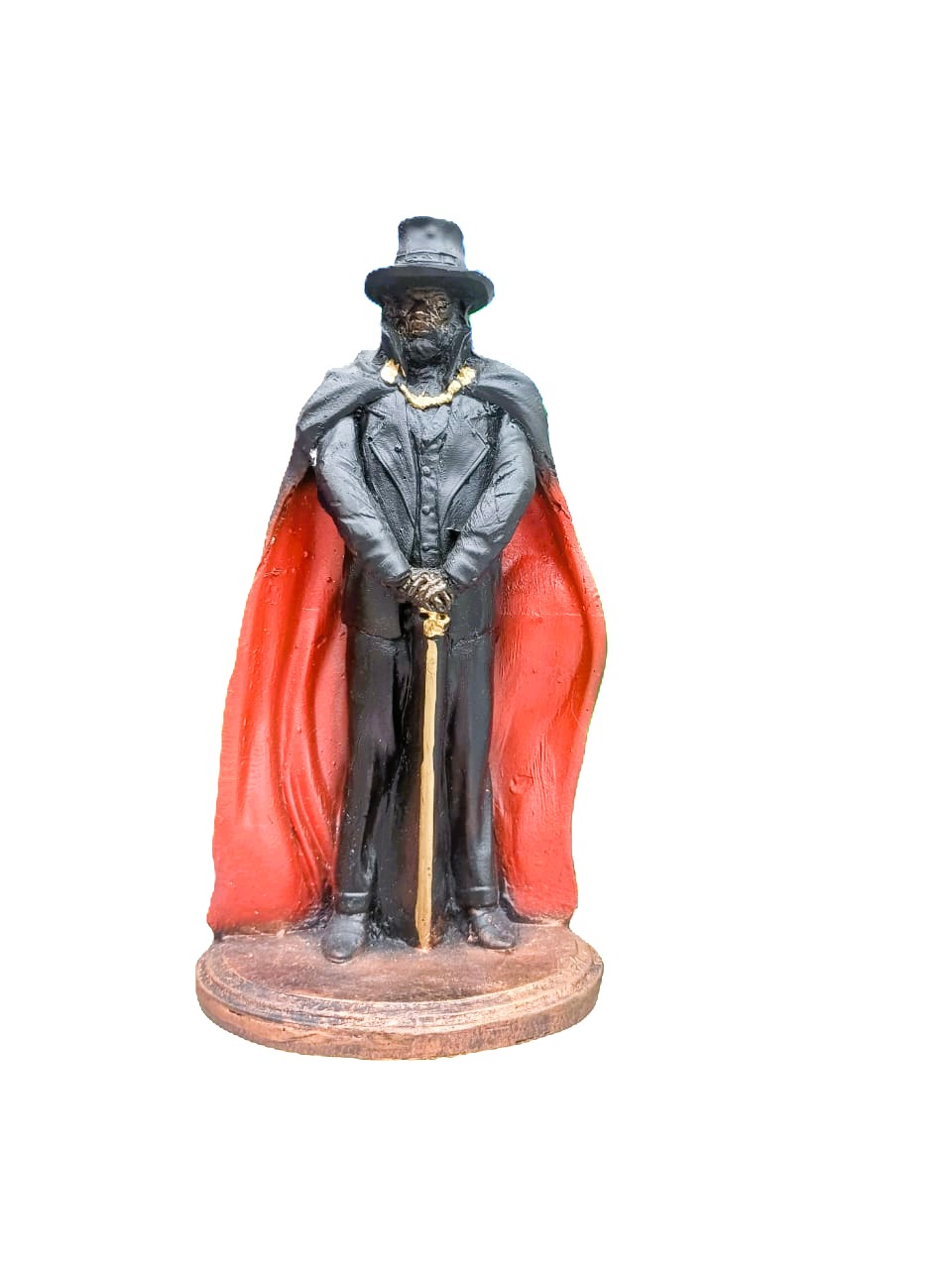 Estátua de figura masculina com capa vermelha e chapéu preto.
