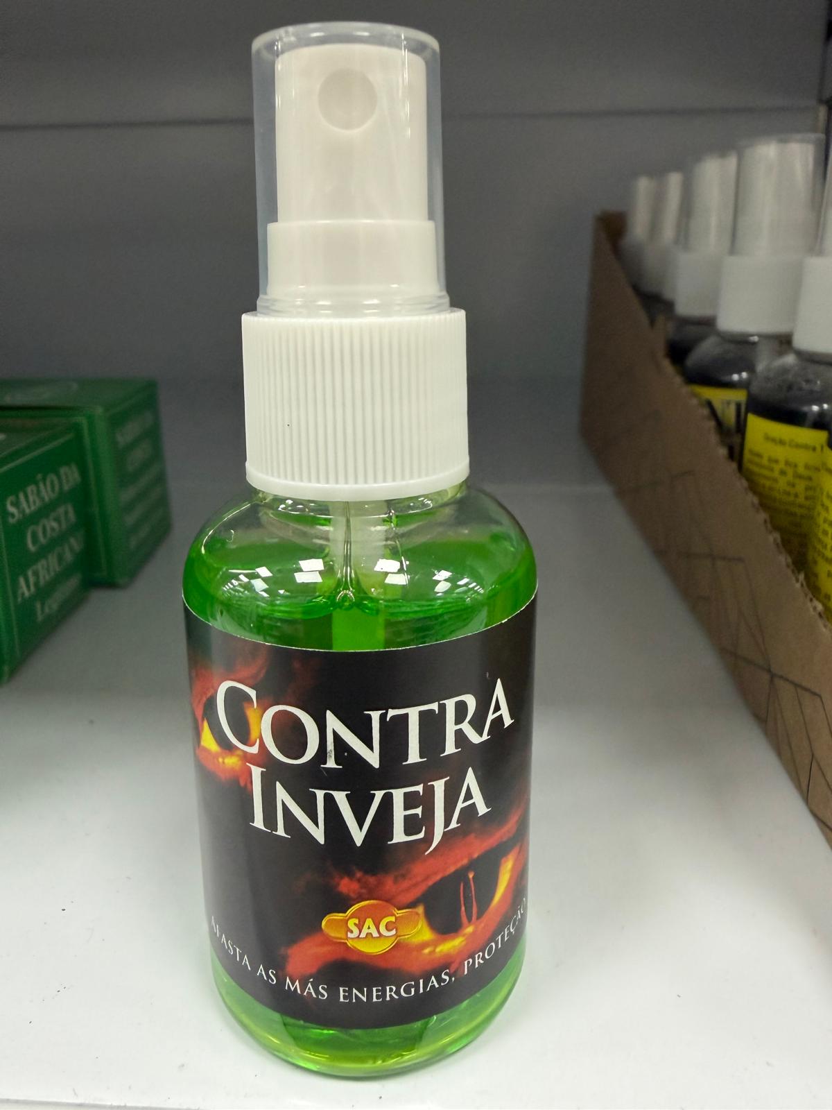 Frasco de spray contra inveja com líquido verde em prateleira