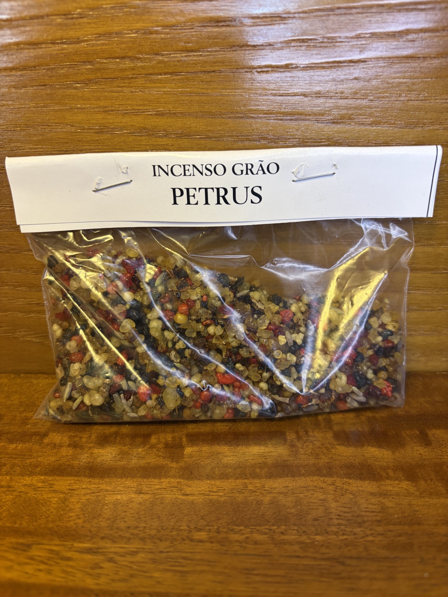 Pacote plástico com grãos de incenso coloridos rotulado como PETRUS