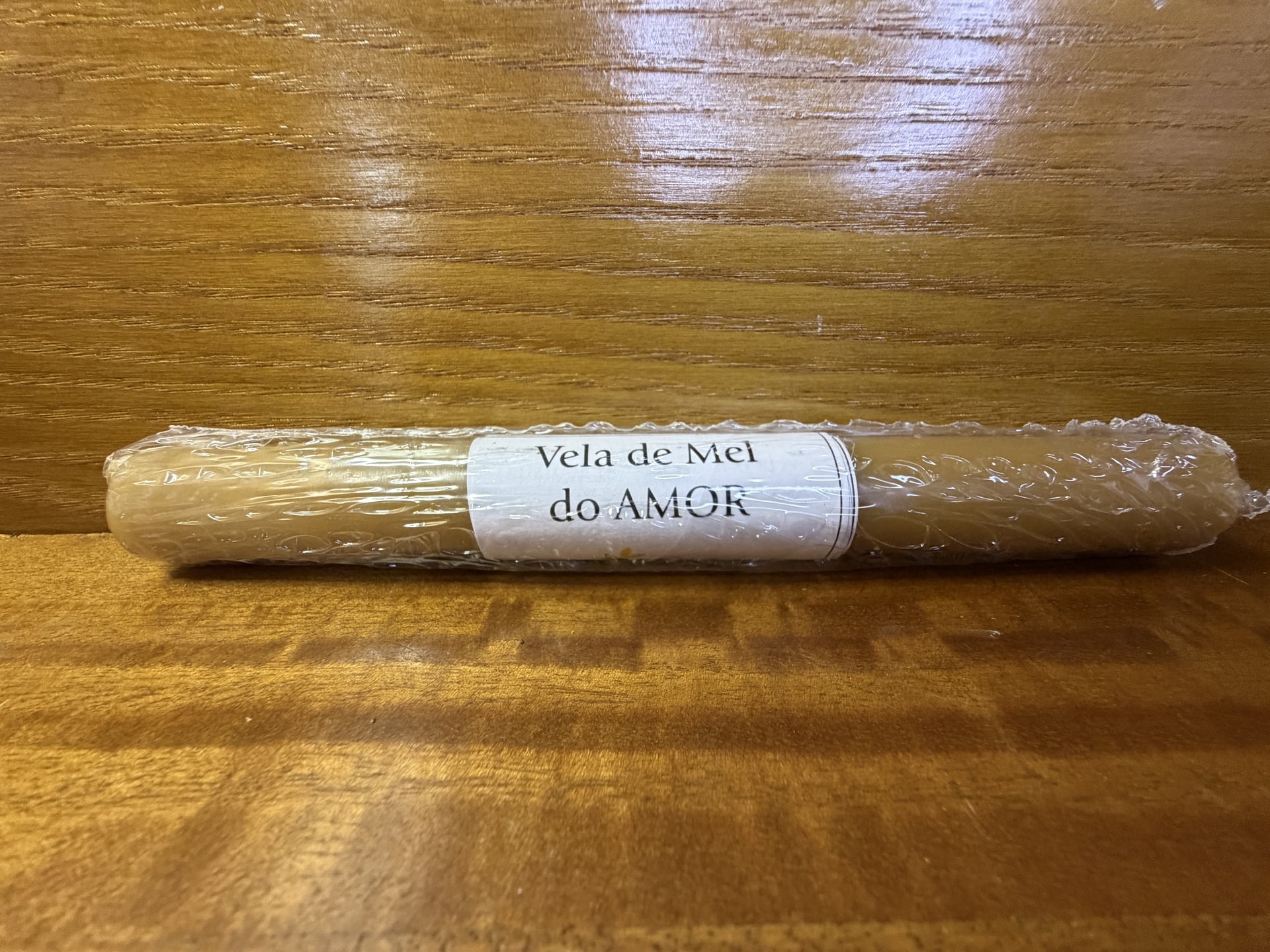 Vela de Mel do Amor embalada em plástico bolha sobre madeira