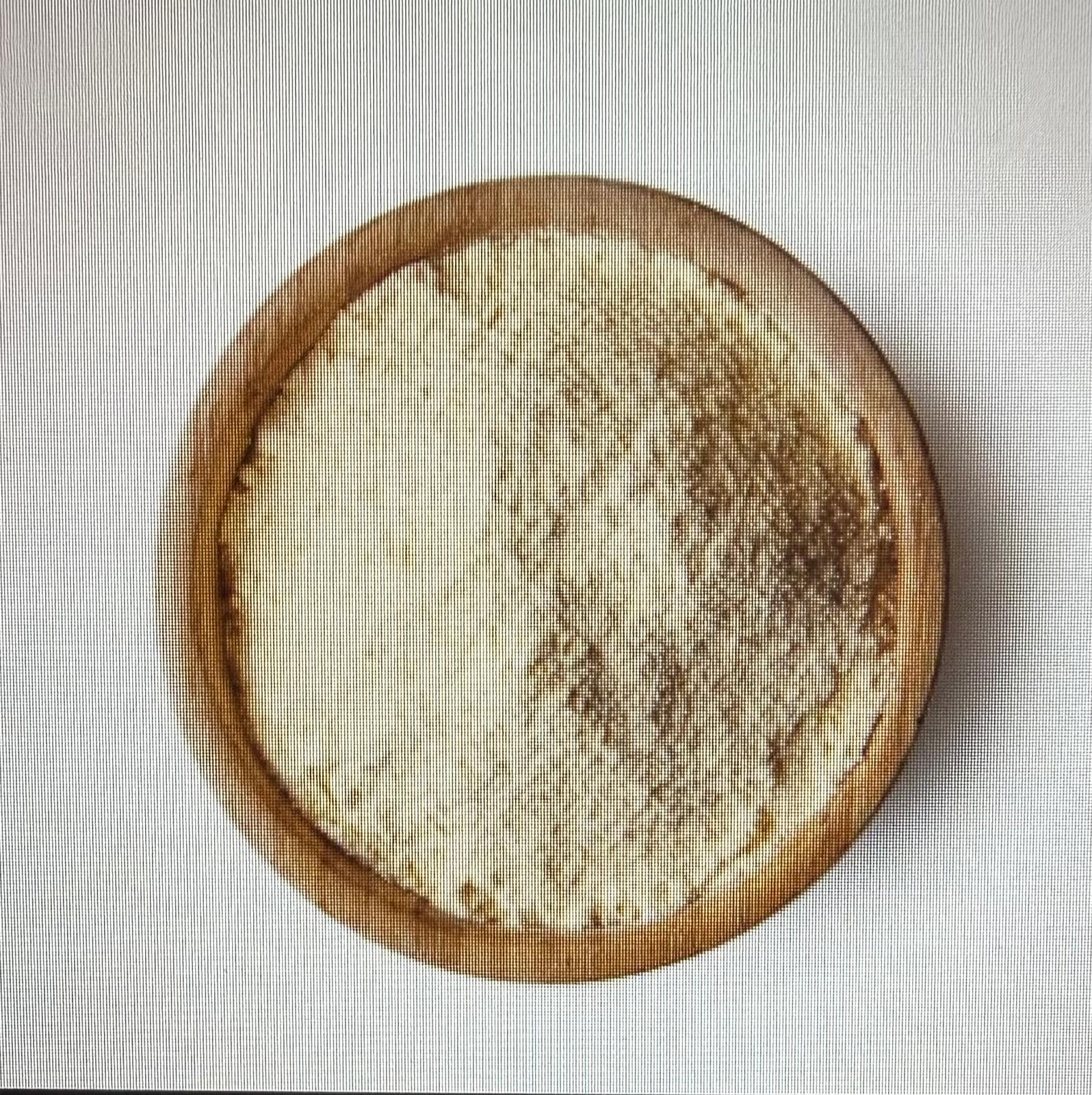 Tigela de madeira com pó branco em fundo branco