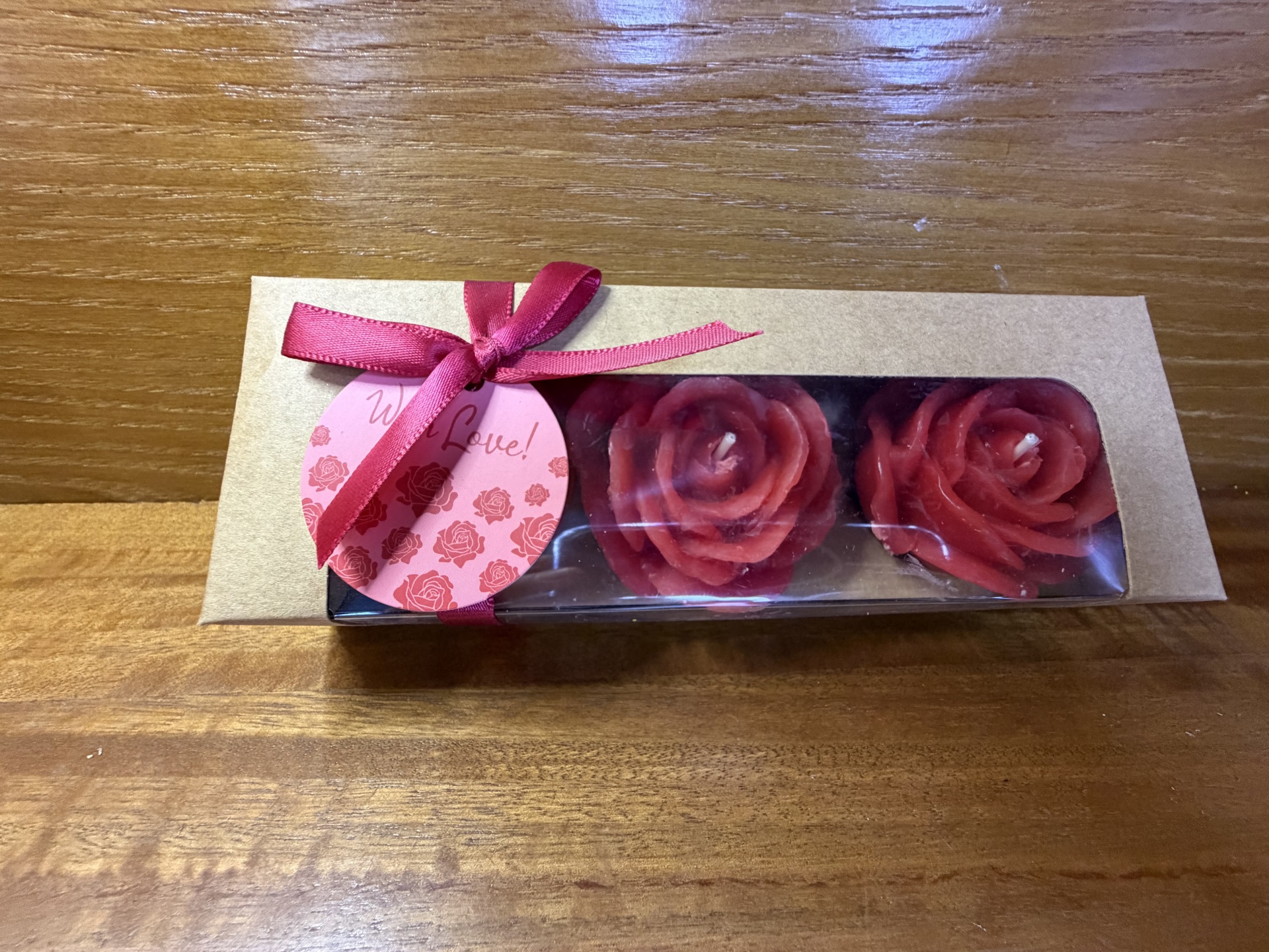 Caixa de velas em forma de rosas vermelhas com laço e etiqueta cor de rosa