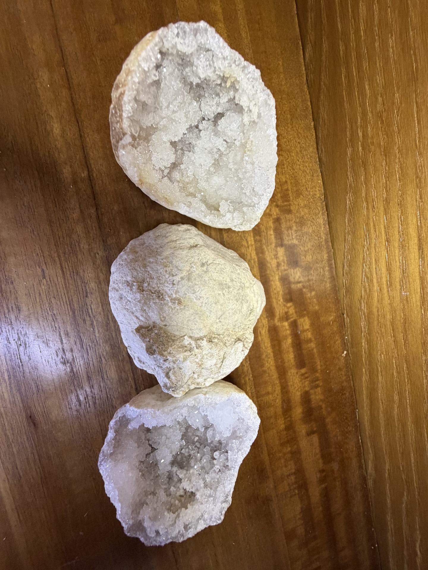 Geodos brancos com cristais sobre superfície de madeira