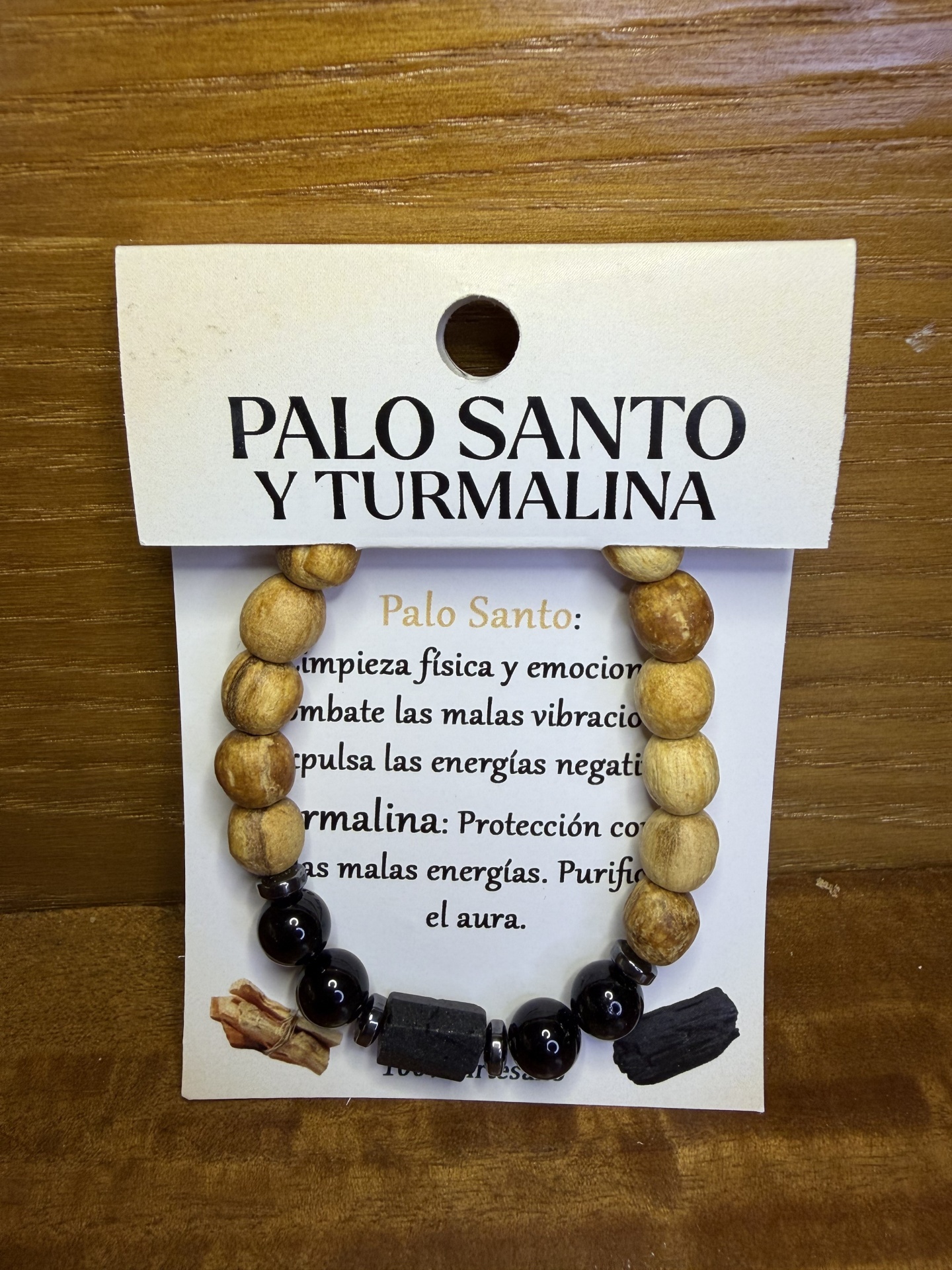 Pulseira de contas de madeira clara e contas pretas com cartão branco de identificação