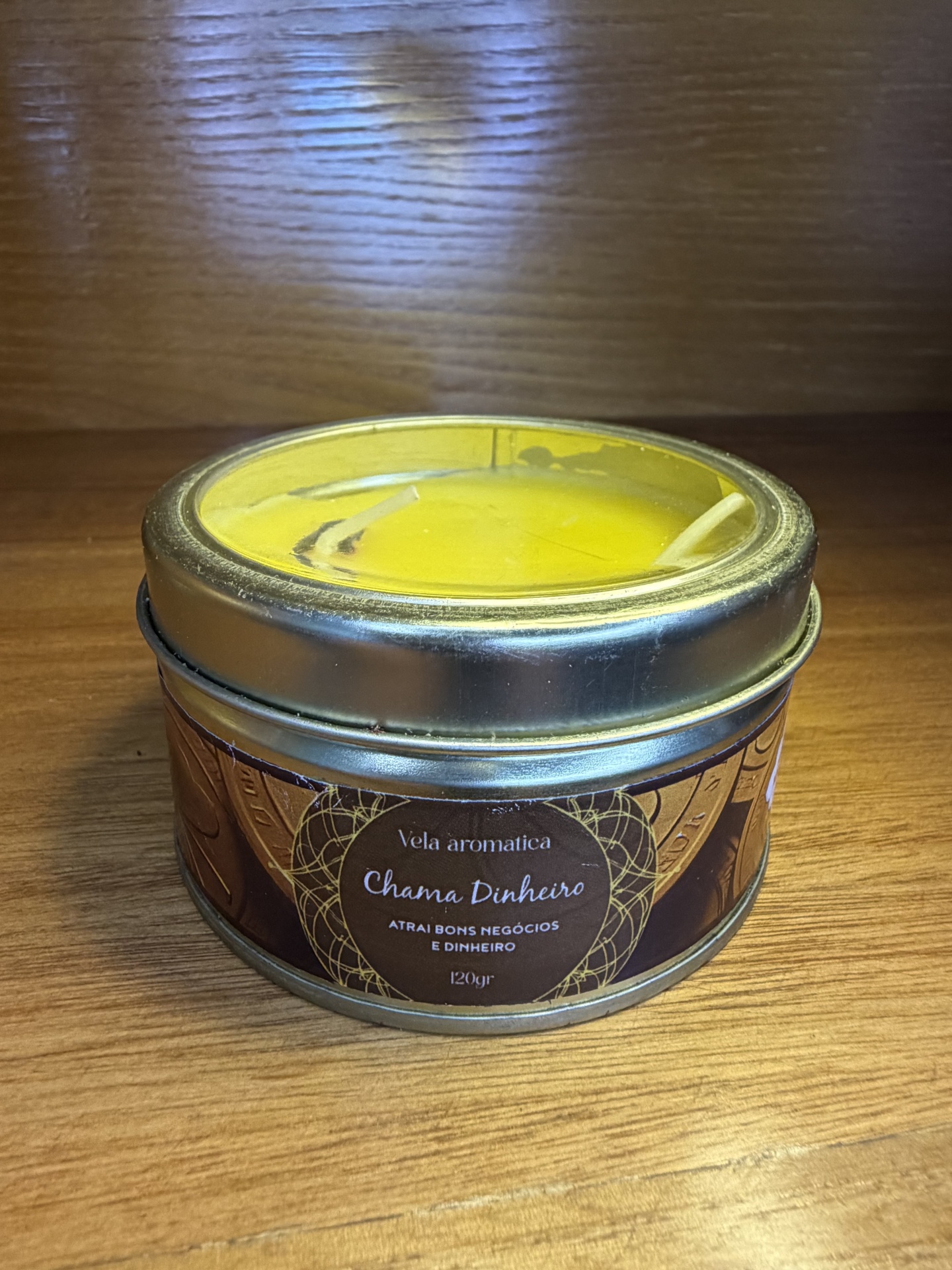 Vela aromática amarela em lata metálica com rótulo castanho