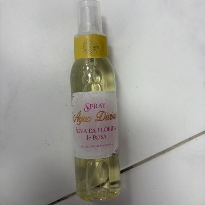 Frasco spray Água Divina amarelo claro com rótulo branco e tampa transparente
