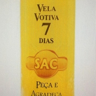 Vela votiva amarela com texto em preto e símbolo SAC