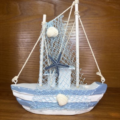 Barco decorativo em madeira azul e branca com rede azul e conchas marinhas