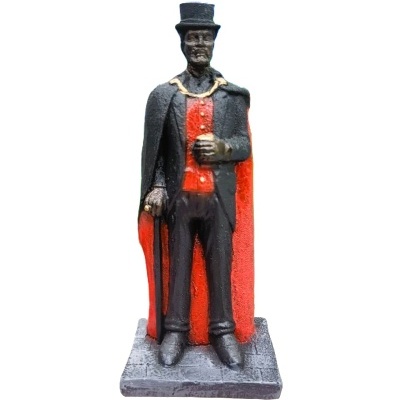 Estátua decorativa de homem com cartola e capa preta e vermelha