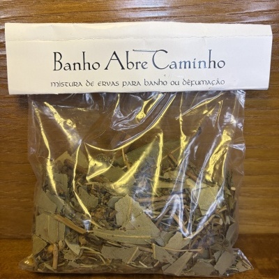Pacote plástico com ervas secas e rótulo branco Banho Abre Caminho