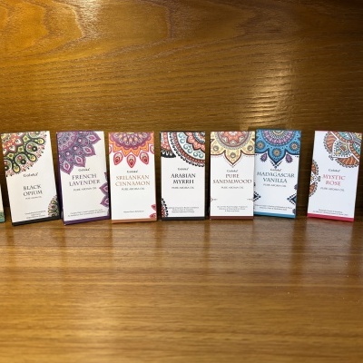 Caixas coloridas de óleos aromáticos Goloka alinhadas sobre superfície de madeira