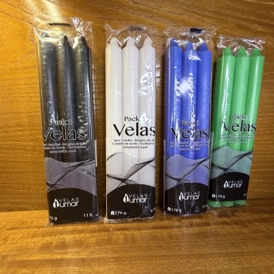 Pacote de velas de várias cores em plástico transparente em fundo de madeira