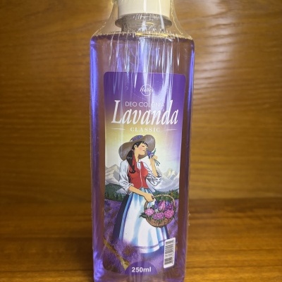 Garrafas de plástico com colónia Lavanda de cor roxa e rótulo ilustração de mulher com vestido tradicional e flores.