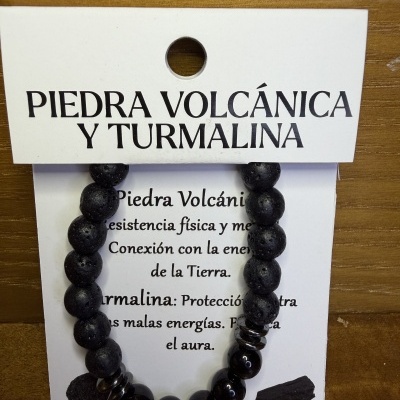 Pulseira com pedras pretas vulcânicas e turmalina num cartão informativo com texto em espanhol