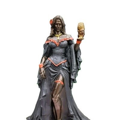 Figura decorativa de mulher em vestido preto com detalhes em vermelho segurando copo dourado