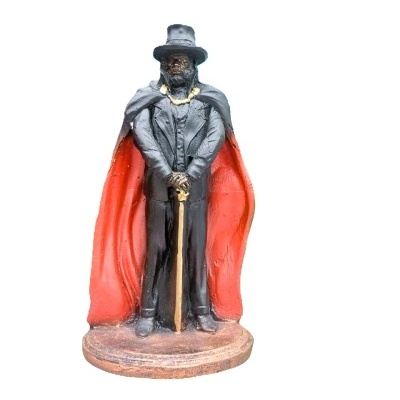 Estátua de figura masculina com capa vermelha e chapéu preto.