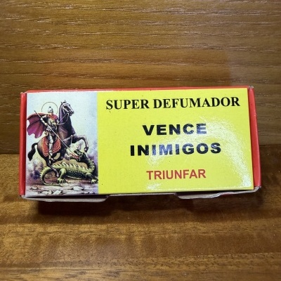 Caixa de papel com ilustração de cavaleiro em cavalo e texto SUPER DEFUMADOR VENCE INIMIGOS TRIUNFAR.