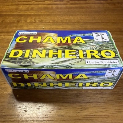 Embalagem de defumador Chama Dinheiro com 20 tabletes sobre mesa de madeira