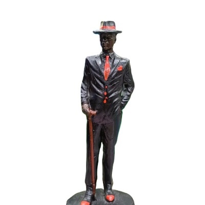 Estatueta de homem de fato preto e gravata vermelha com bengala.