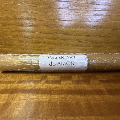 Vela de Mel do Amor embalada em plástico bolha sobre madeira