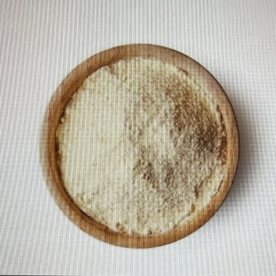Tigela de madeira com pó branco em fundo branco