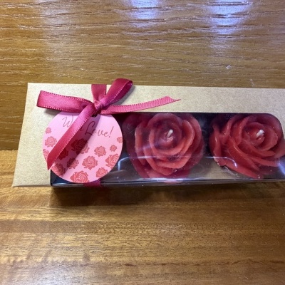 Caixa de velas em forma de rosas vermelhas com laço e etiqueta cor de rosa
