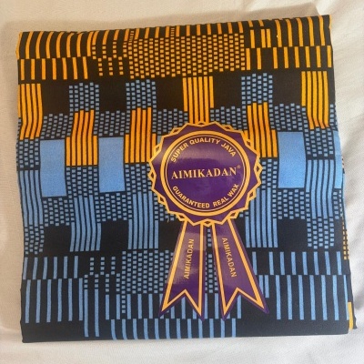 Tecido estampado azul, preto e amarelo com etiqueta AIMIKADAN