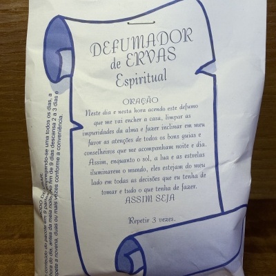 Pacote branco com desenho e texto em português sobre defumador de ervas espiritual